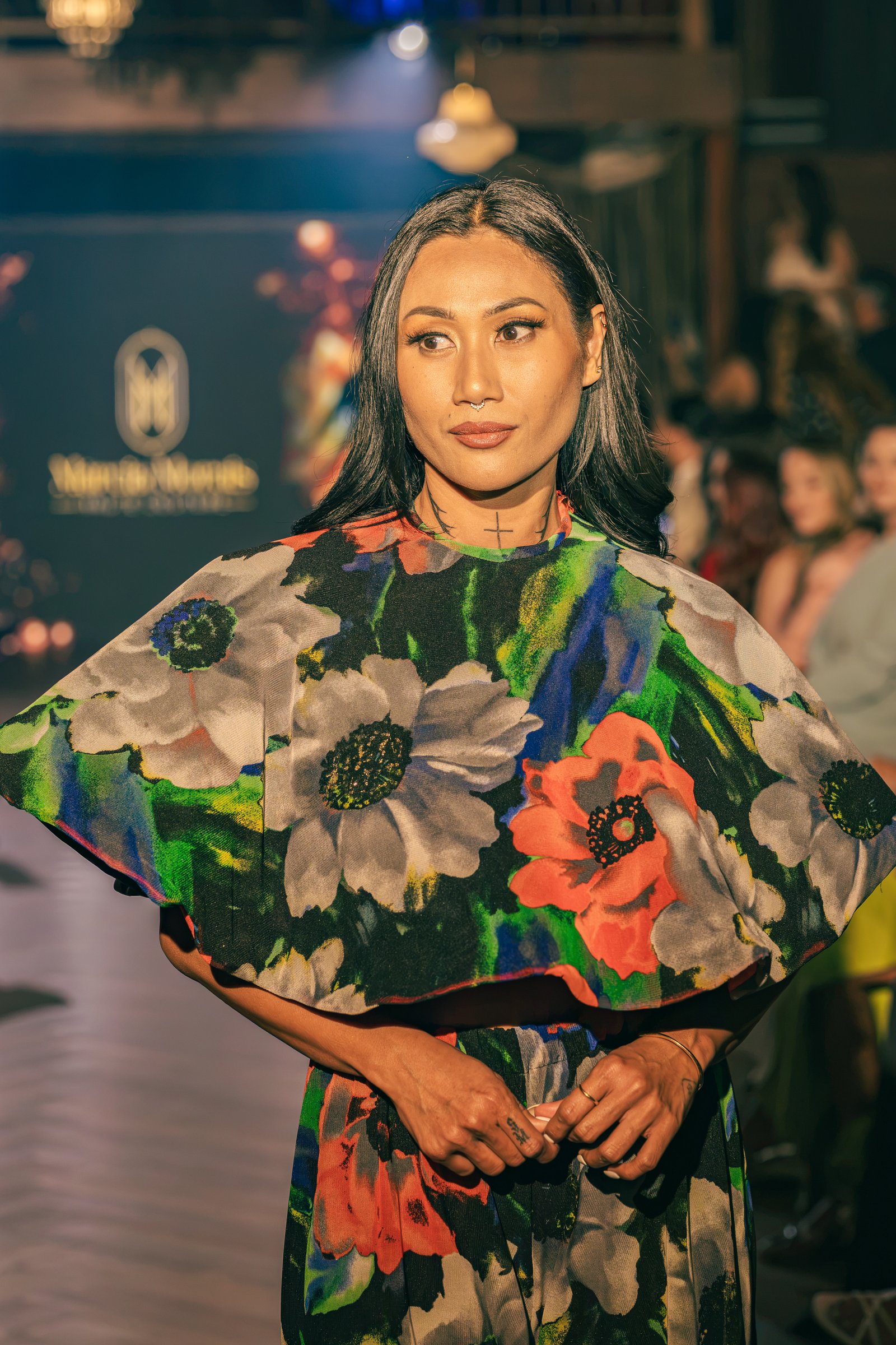 Runway model wearing a striking vibrant floral print cape top